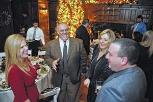 Enjoying some holiday cheer, Benco Dental employees, Marcy Petrucci of West Wyoming, Mario and Debbie Giovanelli of Plains Township and Bill Petrucci of West Wyoming socialize during the company's annual Holiday Party held in the Westmoreland Club. (Photo courtesy Pete G. Wilcox | Times Leader)