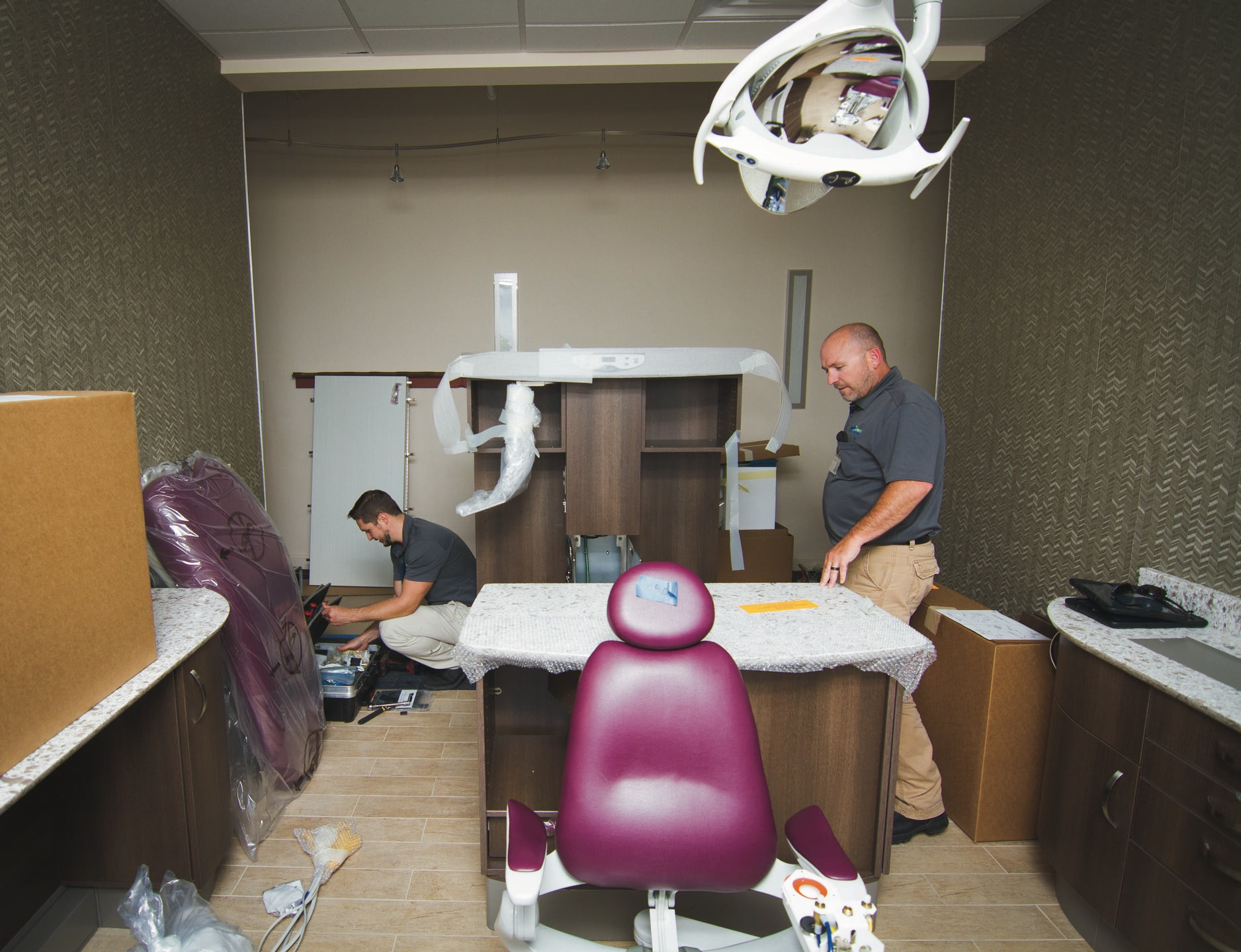 Two members of Benco staff assemble office furniture.