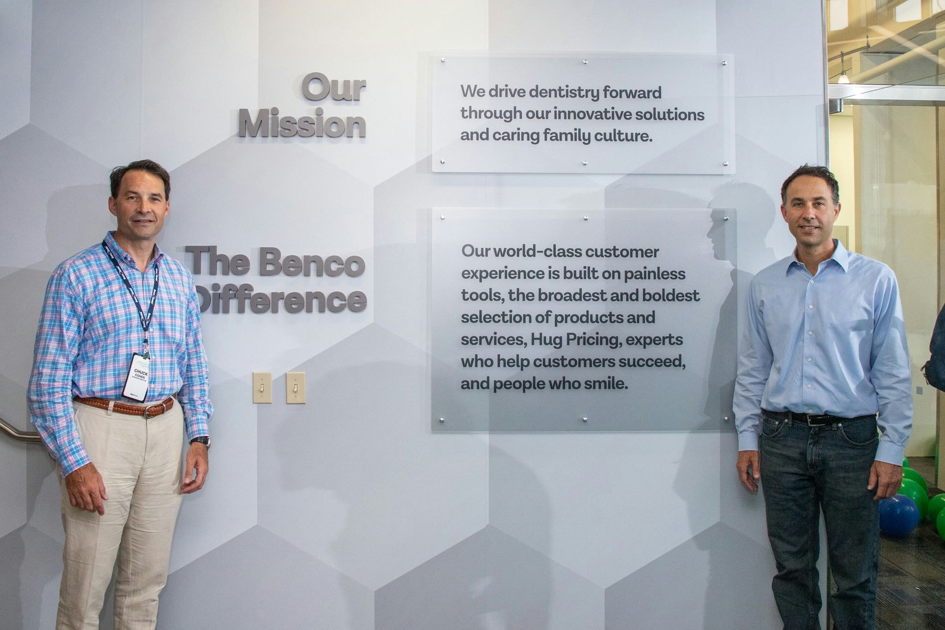 Managing Directors Chuck and Rick Cohen with the new mission statement in the lobby of CenterPoint East home office.