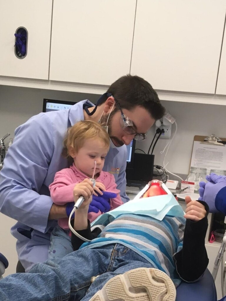 Dr. Nicholas A. Lavoie performing dental procedures on a young patient.