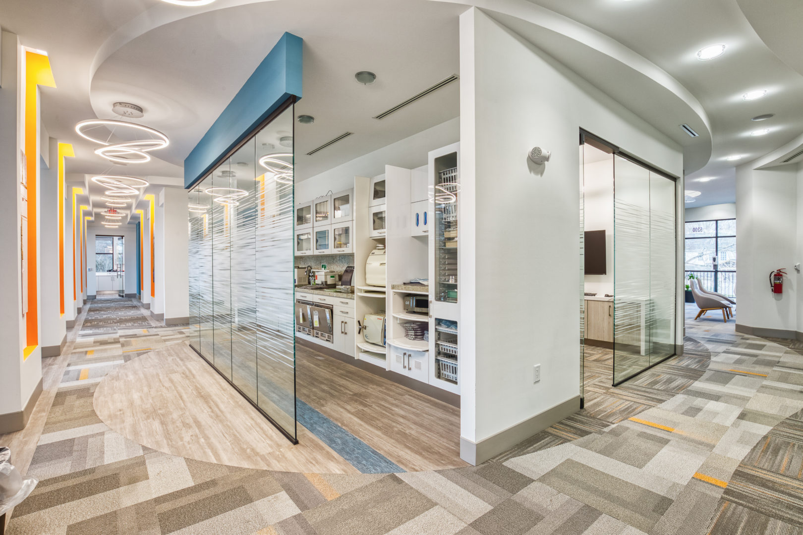 A view of the center of the office highlights stylish glass wall and unique lighting.