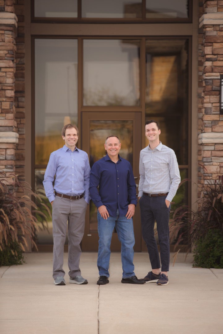 Dr. Swanson stands in front of his practice flanked by his two sons, Dr. Vaubel (left) and Dr. Hemann (right).