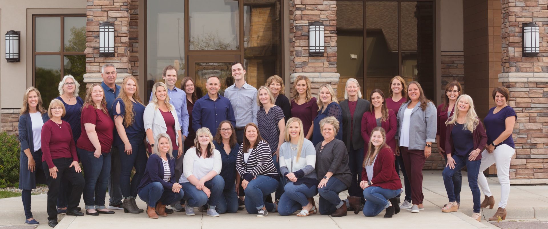 Group photo of the Southern Minnesota Orthodontics team outside their practice.