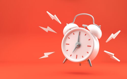 image of a white clock on a red background with electric lines around it indicating ringing.