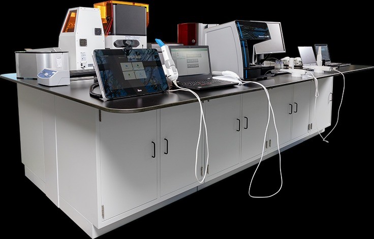 A CAD/CAM table featuring intra-oral scanners and 3D printers.